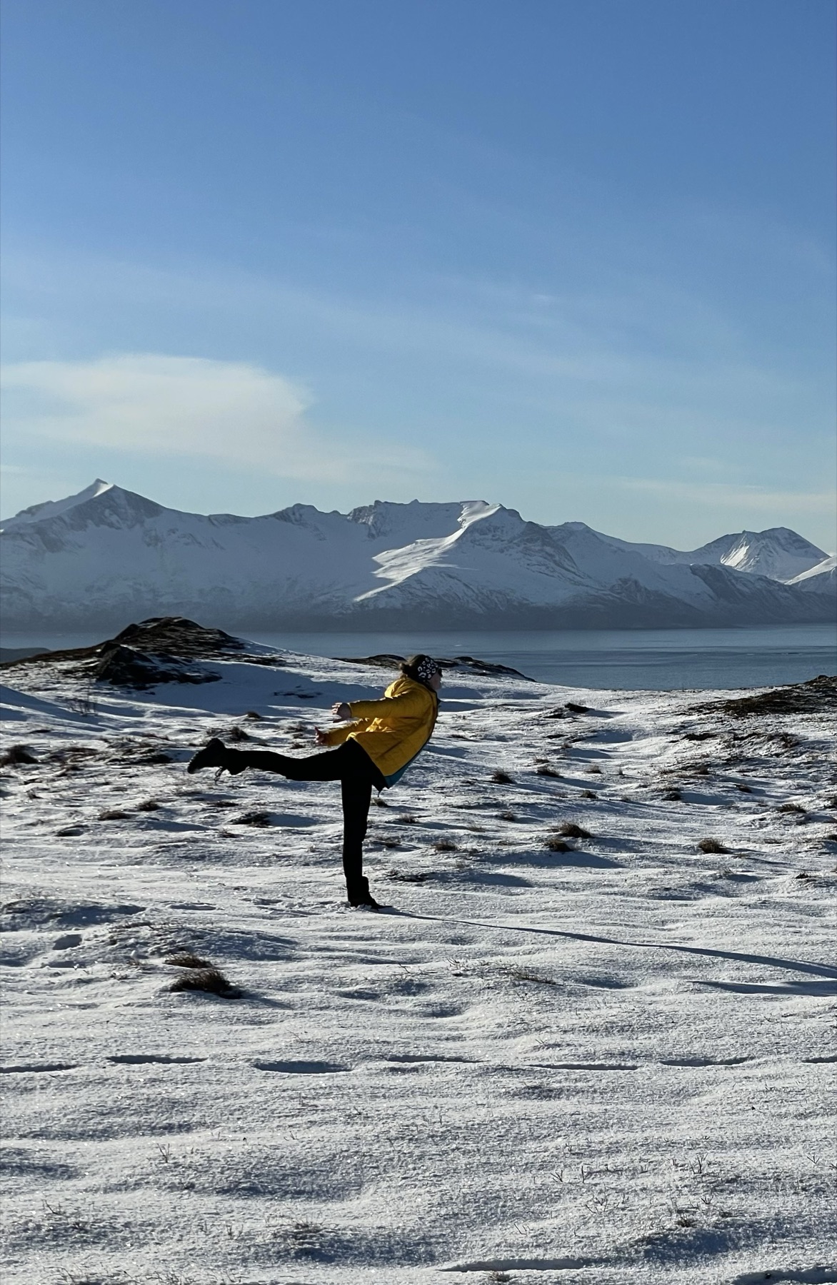 Manon en équilibre sur la neige, face à des sommets enneigés